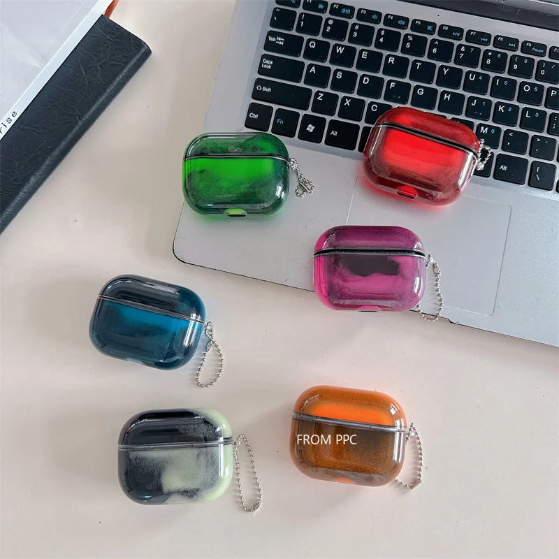 Colorful transparent airpod cases on a desk with a laptop in the background