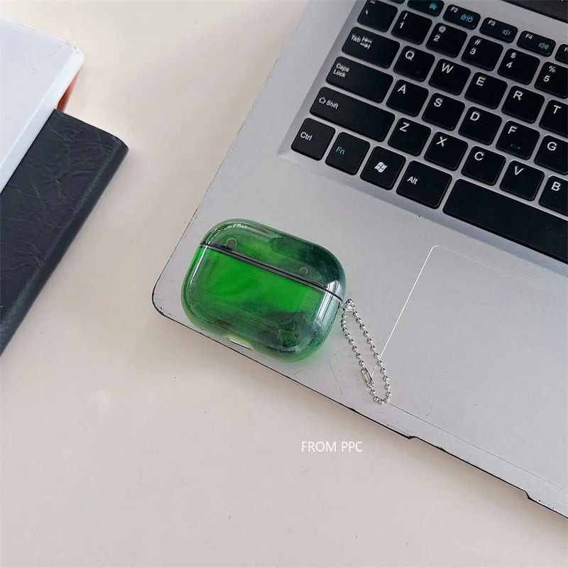 Green air pod case on a laptop with a notebook in the background