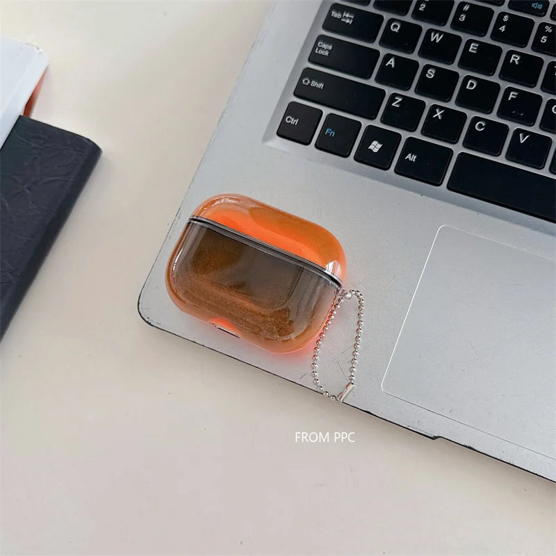 Orange air pod case on a laptop with a blurred background